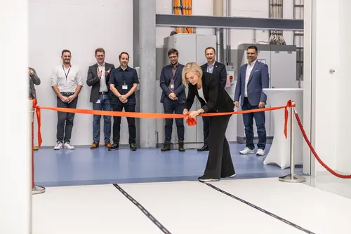 The photo depicts the managing director slicing the red ribbon during the opening of the cleanroom at VON ARDENNE.